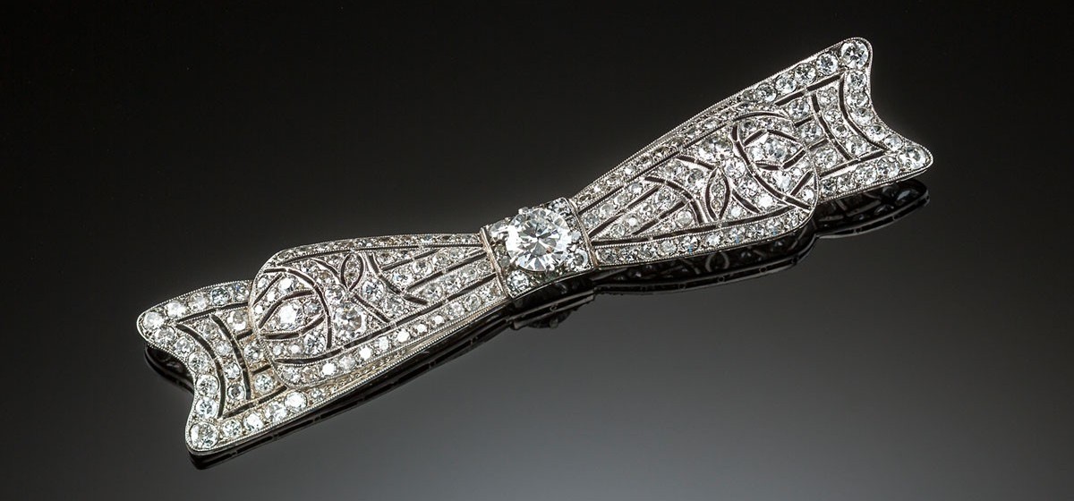 An Art Deco handcrafted platinum and diamond elongated bow brooch 