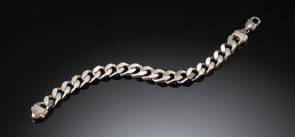 Contemporary sterling silver filed curb link bracelet to shaped ridged caps and a parrot clasp