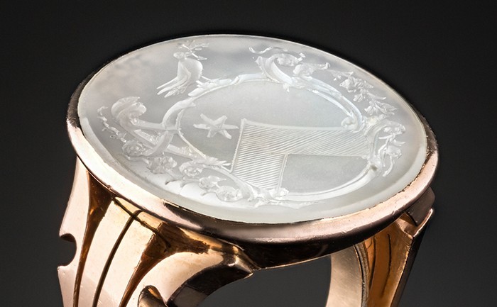 A large antique gold signet ring set with a white chalcedony heraldic shield intaglio