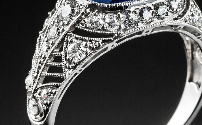 A PLATINUM ART DECO RING WITH A CUSHION SHAPE SAPPHIRE AND TRANSITION CUT DIAMONDS
