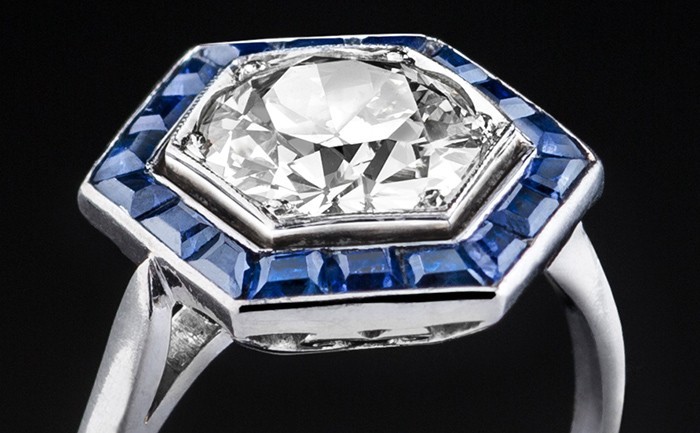 Detail of a French Art Deco platinum and diamond hexagonal ring with a sapphire border