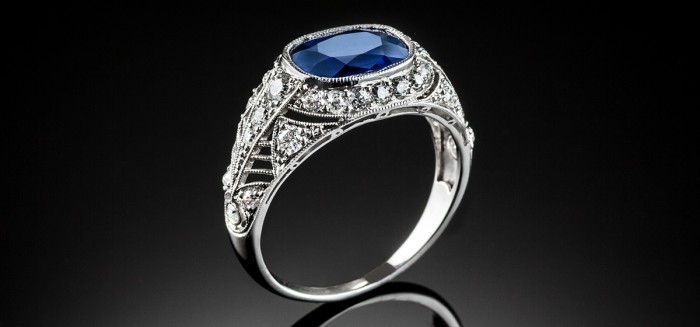 A PLATINUM ART DECO RING WITH A CUSHION SHAPE SAPPHIRE AND TRANSITION CUT DIAMONDS