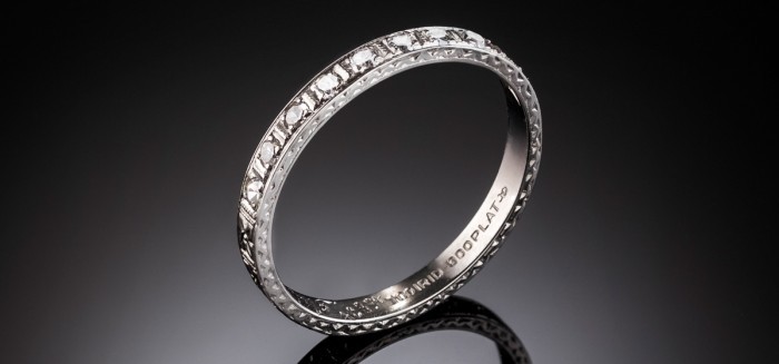 An Art Deco platinum/iridium band, the top with ten diamonds, millegrain and engraving