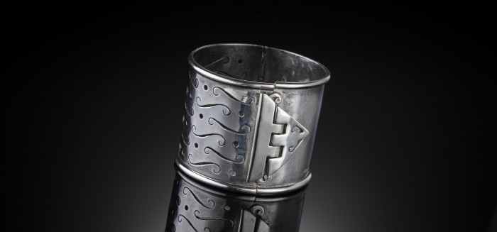 A  SCOTTISH STERLING SILVER WIDE HINGED BANGLE WITH DISTINCTIVE PIERCED DECORATION TO THE FRONT AND CLASP