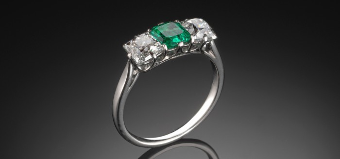 1930S ART DECO EMERALD AND TWO SQUARE CUT DIAMONDS PLATINUM RING