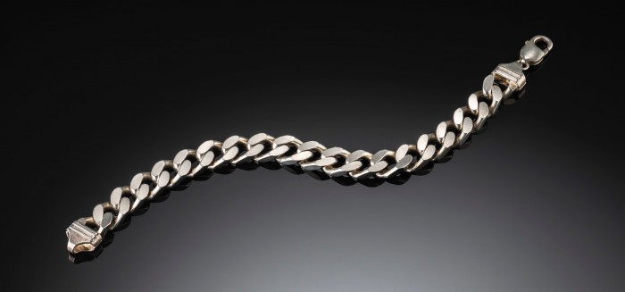 Contemporary sterling silver filed curb link bracelet to shaped ridged caps and a parrot clasp